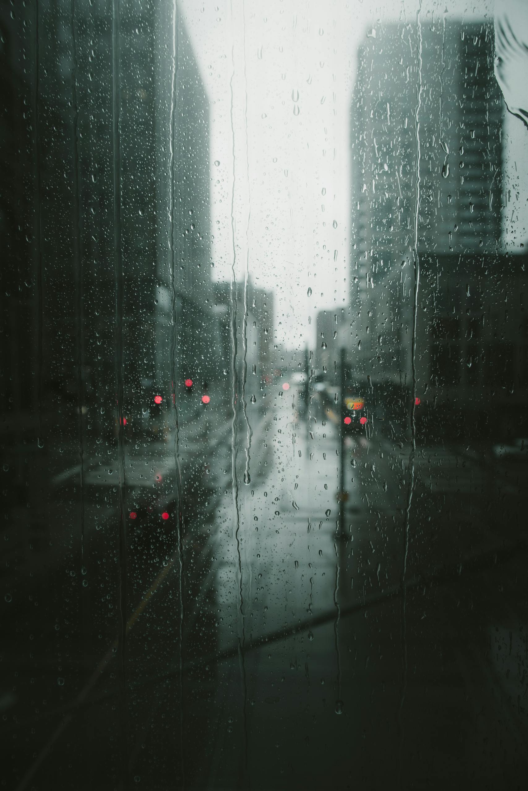 Moody view of a rainy day in Minneapolis, capturing the urban scene through a glass window with raindrops.